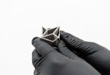 3D printed part held by hands with gloves