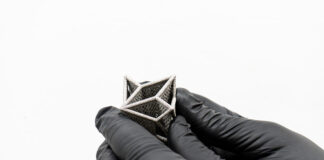 3D printed part held by hands with gloves