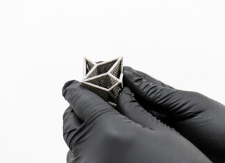 3D printed part held by hands with gloves