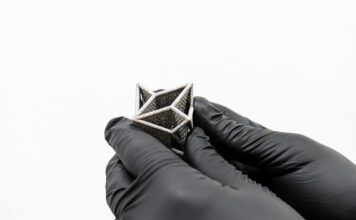 3D printed part held by hands with gloves