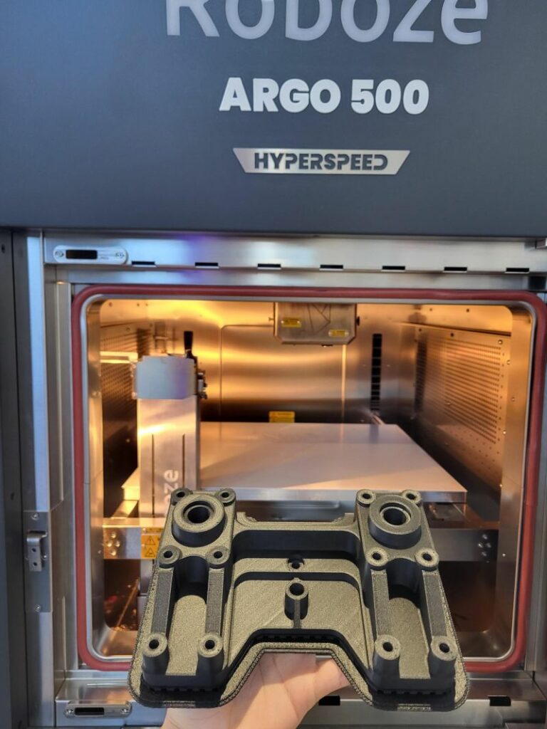 Roboze ARGO 500 Hyperspeed printer with a part visible inside the chamber.