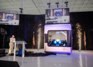 AMPERA Founder and CEO Brian Matthews pulls curtain revealing the first full-scale 3D printed reactor module, featuring a fully 3D printed silicon carbide reactor core and reactor pressure vessel at a celebratory event at the company’s innovation center in Palm Beach Gardens, Fla. (PRNewsfoto/AMPERA)