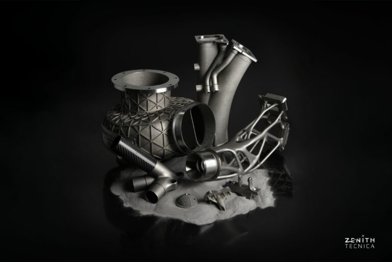 Additively manufactured metal components displayed against a dark background.