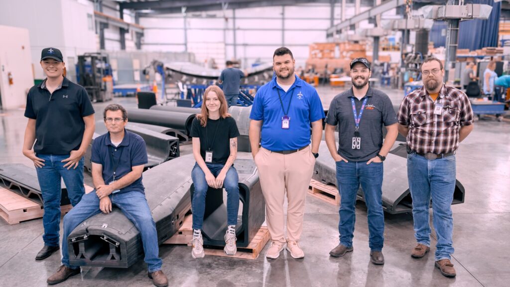 D-J Engineering team beside large printed tooling in a workshop.