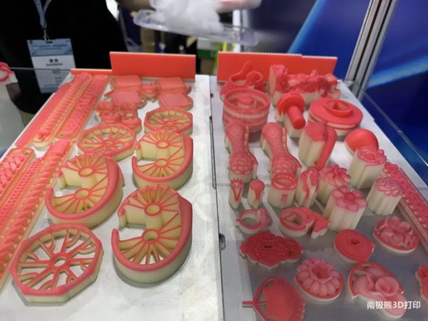 Red wax casting patterns displayed on a table.
