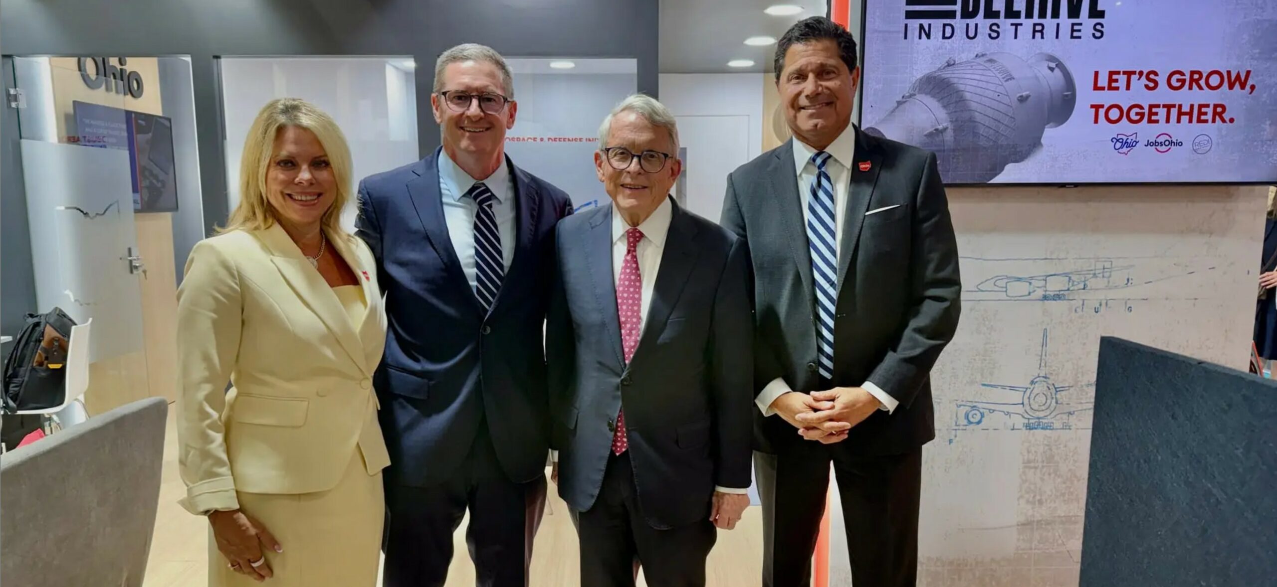 Four people standing together at a Beehive Industries announcement.