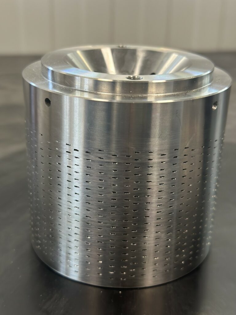 Pièce cylindrique métallique percée de nombreux orifices.