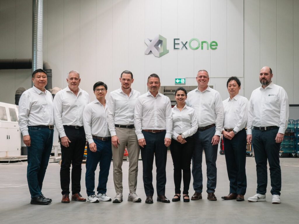 ExOne team standing together inside a company building.