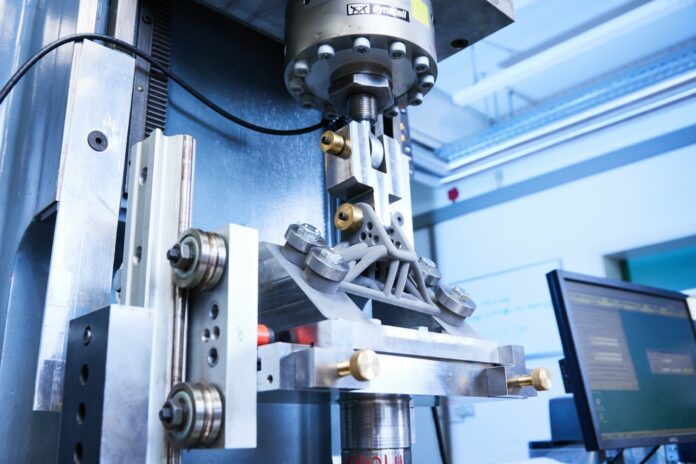 Fraunhofer-IWM-Testaufbau-HZ-KaiWudtke-005 © Fraunhofer IWM, Photo: Kai Wudtke Cyclic load testing of an additively manufactured metal component after me-chanical surface treatment at the highly stressed zones. In the experiment, the increase in service life achieved by the post-treatment is tested.