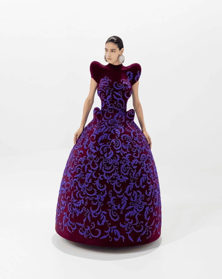 Model wearing a voluminous purple haute couture dress.