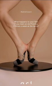 Dancer adjusting black pointe shoes.
