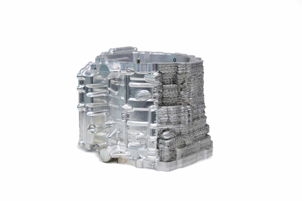 Metal component with complex internal and external features after partial machining.