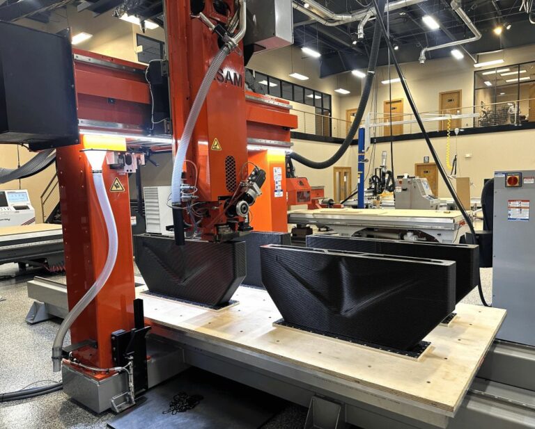Large black part being printed in a Thermwood LSAM installation.