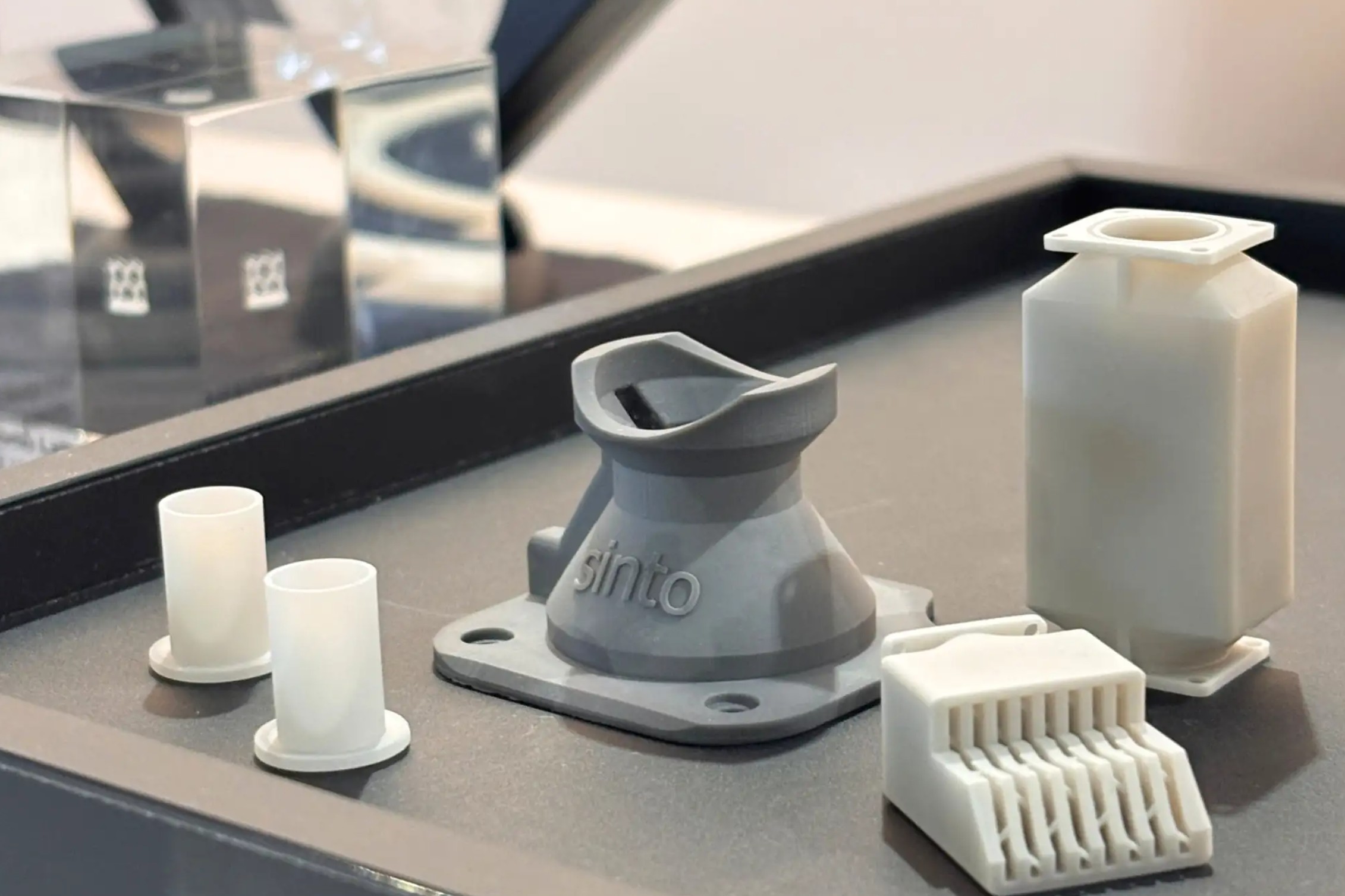 The first publicly displayed non-oxide ceramic components from Sinto Advanced Ceramics Europe GmbH at ESA Industry Space Days 2026: aluminum nitride sleeves (left), a silicon nitride hold-down component (center), and an aluminum nitride heat exchanger (right). © Sinto Advanced Ceramics Europe GmbH